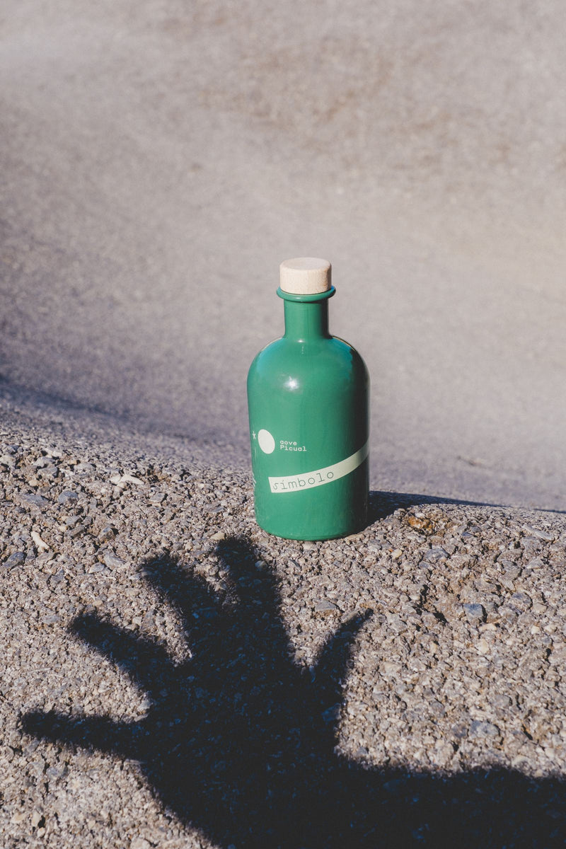 Botella sobre la piedra con la sombra de una mano