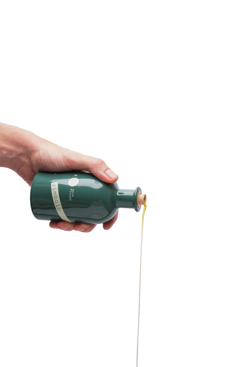 Una mano vierte el aceite de oliva virgen extra desde la botella